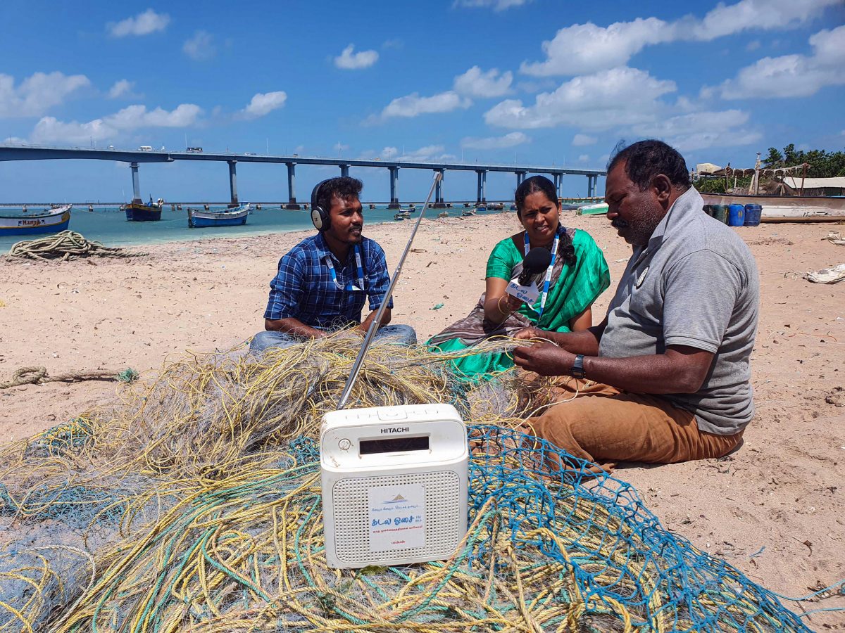 Radio jockeys from Sound of the Sea interview a fisherman on the beach